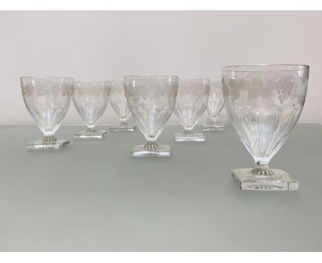A set of seven early 19th century glass rummers, each ogee bowl with a band of fruiting vine over a slice-cut and moulded bas