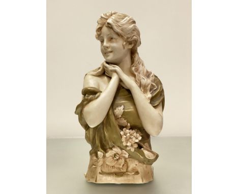 A Royal Dux porcelain bust by Herman Schubert, modelled as a girl looking dexter, a corsage at her breast, signed verso and d