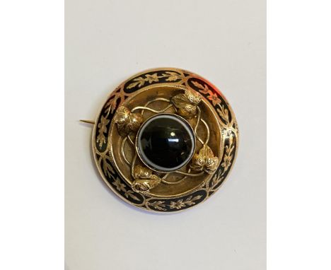 A late Victorian tiger's eye mourning brooch, mounted in yellow metal, circular, the central cabochon stone within a border m