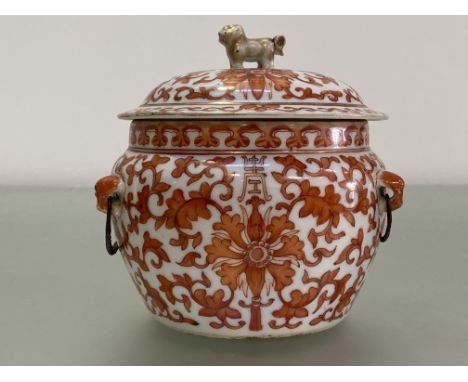 A Chinese porcelain jar and cover, of compressed baluster form, decorated with scrolling flowers and foliage in iron red / or