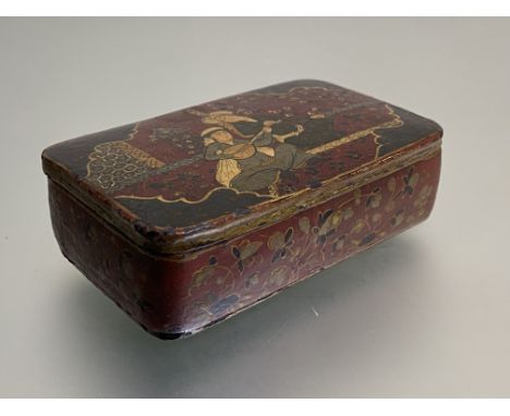 A Persian papier mache snuff box, 19th century, of oblong form, the cover decorated with a musician and another figure within
