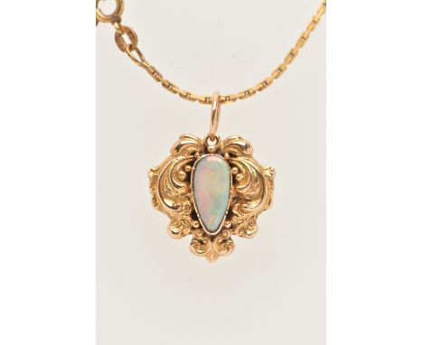 A YELLOW METAL OPAL MOURNING PENDANT WITH AN ARTICULATED CHAIN, the pendant set with a white opal cabochon, within a foliate 