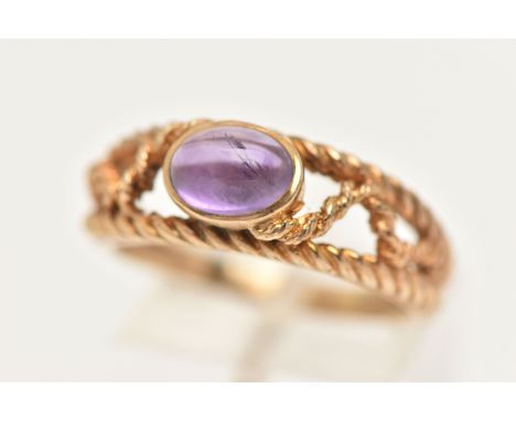 A 9CT GOLD AMETHYST RING, set with an oval amethyst cabochon, collet set to the open work rope twist surround and shoulders, 