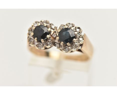 A 9CT GOLD SAPPHIRE AND DIAMOND DOUBLE CLUSTER RING, designed as two round clusters, each set with a central circular cut blu