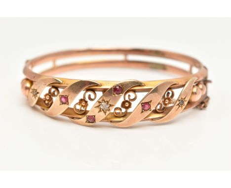 A VICTORIAN ROSE METAL BANGLE, open work design set with a central old cut diamond, two rose cut diamonds and four circular c