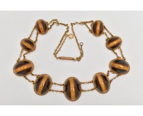 A YELLOW METAL TIGER EYE CABOCHON NECKLACE, designed as a series of nine graduated oval tiger eye cabochons, each collet set 