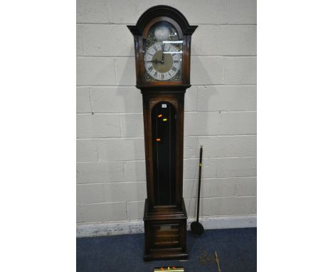 A 20TH CENTURY OAK LONGCASE CLOCK, the arched hood with a bevelled glass door, that's enclosing a 9 inch brass and silvered d