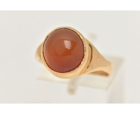 A YELLOW METAL CARNELIAN CABOCHON RING, set with an oval cut carnelian cabochon, collet set to the polished band, unmarked me
