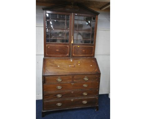 A GEORGIAN MAHOGANY BUREAU BOOKCASE, with a broken arch pediment, a ball and eagle finial, the double glazed doors enclosing 