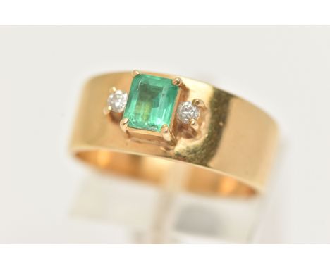 A YELLOW METAL EMERALD AND DIAMOND RING, set with a raised emerald cut emerald, measuring approximately length 5.2mm x 4.6mm,