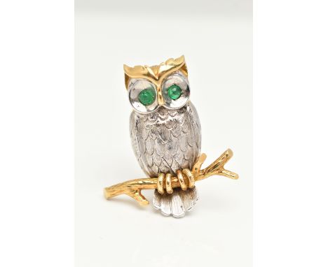 AN 18CT YELLOW AND WHITE GOLD OWL BROOCH, realistically textured owl perched on a branch, set with emerald cabochon eyes, fit