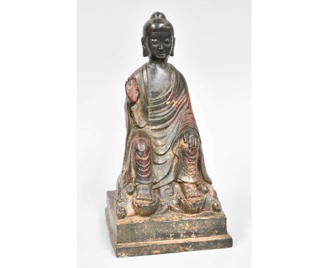 A Sino-Tibetan Parcel Gilt and Polychrome cast Metal Statue of Buddha, seated on a rock over a stepped plinth, 23cm