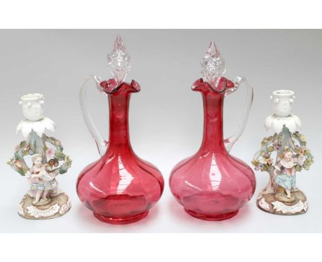 A Pair of Sitzendorf Porcelain Candlestick Figures, and a pair of cranberry glass claret jugs and stoppers (4)