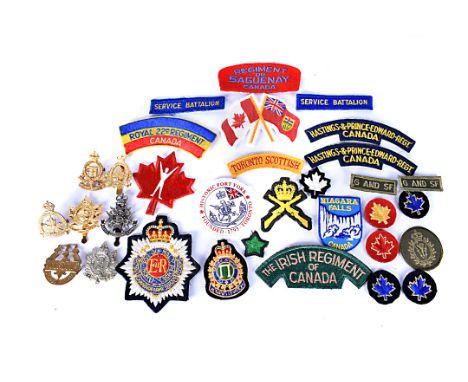 A collection of Canadian metal and cloth badges,  to include 2nd Queen's Own Rifles of Canada, Royal Canadian Ordnance Corps,