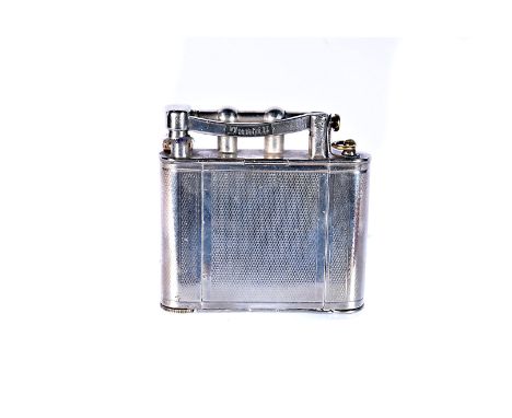 An early 20th century Dunhill Vanity lighter, the white-metal lighter with engine turned design, complete with folder out mir