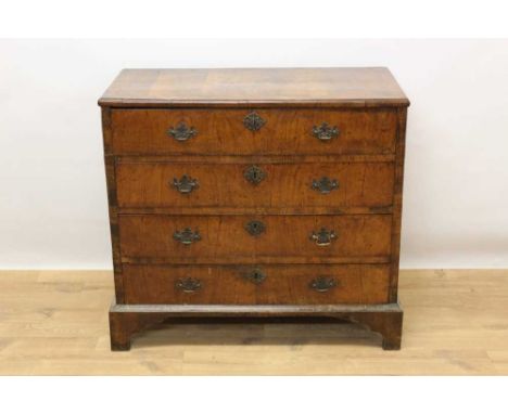 Early 18th century walnut chest, with crossbanded top and four long drawers, each with brass drop handles on bracket feet, 92