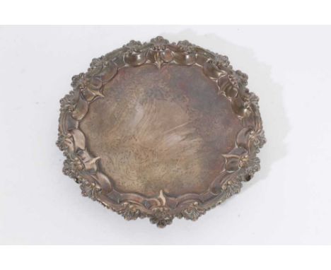 Victorian silver waiter of circular form, with decorative shell and scroll border, foliate engraved central panel, on three s