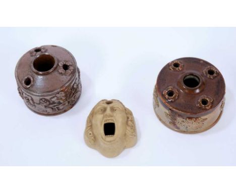 Three 19th century stoneware inkwells, the first of mask form, 6.5cm long, and the other two salt glazed, of circular form wi