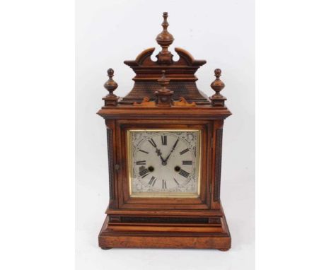 Late 19th century German mantel clock with silvered dial, German movement striking on gong in architectural carved walnut cas