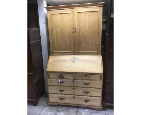 George III pine bureau cabinet, with panelled upper section enclosing shelves, sloping fall with fitted interior, two short o