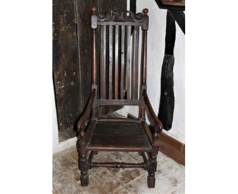 17th century oak open arm chair with pierced top rail and vertical slat back. Panel seat, on turned and block understructureP