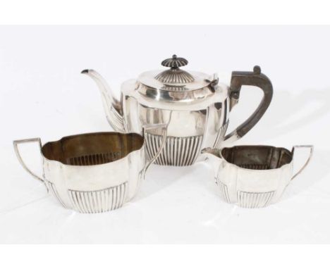 Late Victorian silver three piece teaset comprising teapot of oval form with fluted decoration, domed hinged cover with ebony