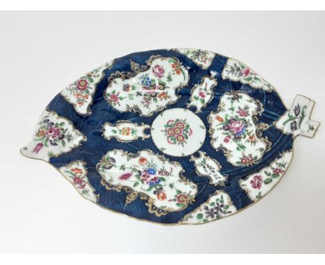 A large Worcester cabbage-leaf-shaped dish, circa 1770, decorated with floral reserves on a blue scale ground, pseudo-Chinese