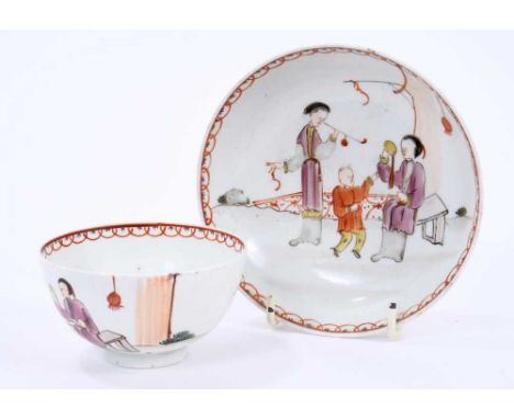 Lowestoft tea bowl and saucer, painted in the Mandarin style with three figures, one smoking a pipe, within a red overlapping