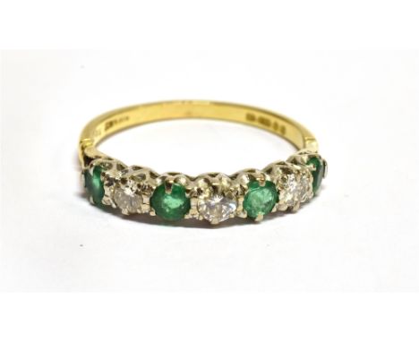 AN EMERALD AND DIAMOND HALF ETERNITY SEVEN STONE 18 CARAT GOLD RING  three round brilliant cut diamonds with a total diamond 