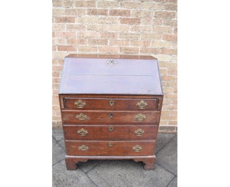 A GEORGE III PROVINICIAL OAK BUREAU  with fitted interior above four long graduated drawers, on bracket feet, 84cm wide 52cm 