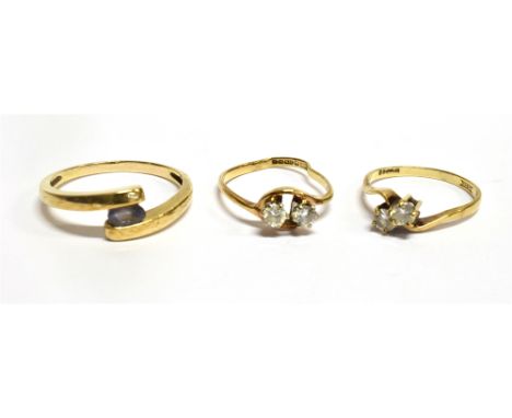 THREE YELLOW GOLD STONE SET CROSSOVER RINGS comprising a blue stone set ring, unmarked, assessed as 9 carat gold, ring size Q