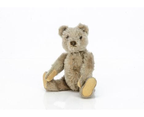 A post-war Steiff teddy bear,  with beige mohair, clear and black glass eyes with brown backs, pronounced muzzle, brown stitc