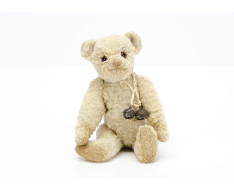 A small 1930s Invicta teddy bear,  with white artificial silk plush, orange and black glass eyes, pronounced muzzle, pale bro