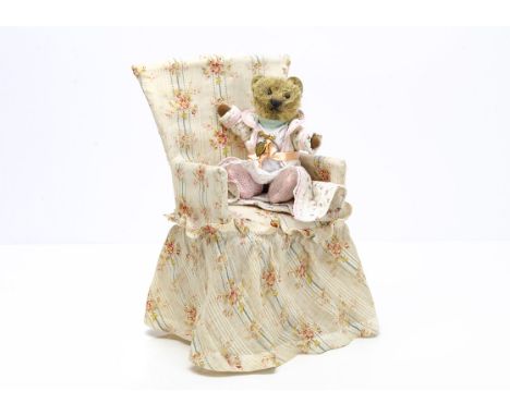 A small German 1920s teddy bear,  with dark blonde mohair, black boot button eyes, black stitched nose and mouth, swivel head