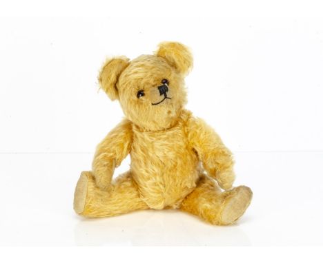 A post-war Alpha Farnell teddy bear,  with golden mohair, orange and black glass eyes, black stitched nose and mouth, pronoun