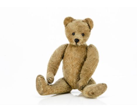 An early British teddy bear 1915-1920, with sparsely woven blonde mohair, black boot button eyes, pronounced muzzle, black st