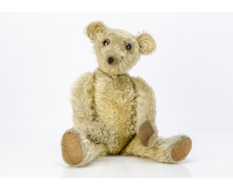 An early Chad Valley teddy bear,  with blonde mohair, clear and black glass eyes with brown painted backs, pronounced muzzle,