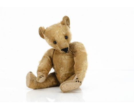 An early teddy bear circa 1910,  German or American with golden mohair, black boot button eyes, pronounced muzzle, black stit