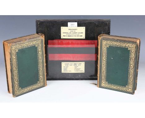 A First World War period brassard, within a framed and glazed display with celluloid plaques detailed 'Brassard worn by Gener