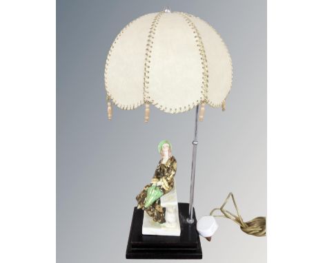 A 1930's porcelain figural table lamp with shade on wooden stand 