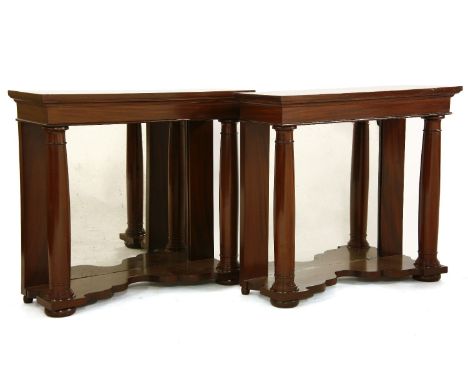 A pair of mahogany console tables, with plain turned columns, mirror backed, on a shaped plinth, 101.5cm wide x 34cm deep x 9