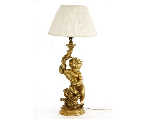 A gilded cherub lamp with wire shade support