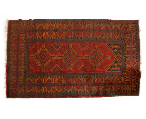 A small red ground carpet, with geometric triple medallion within banded border