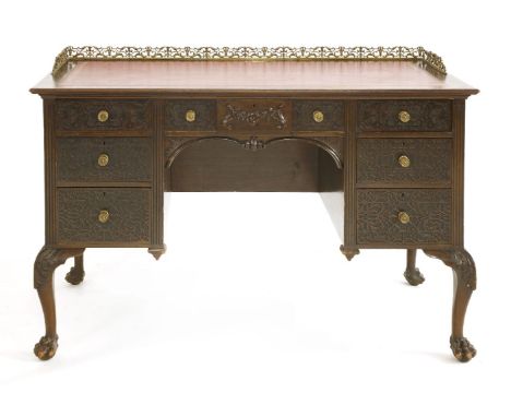 An Edwardian Chippendale style mahogany desk, with blind fretwork decoration to the drawers and all on claw and ball feet, 12