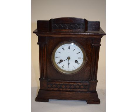 A circa 1920s oak mantle clock, key and pendulum 