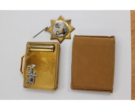 A new Kigu powder compact and lipstick case with original paper label, together with a George VI and Queen Elizabeth 1937 pin