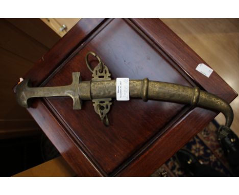 An Arabian dagger with curved 22cm blade with Arabic inscription. All brass grip with decoration. Complete with brass scabbar
