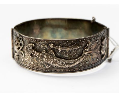 A white metal hinged bangle having Turkish applied decoration, with an internal diameter of approx 65mm and a gross weight of