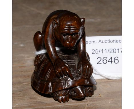 A Japanese dark wood carved Netsuke, depicting a Monkey sitting on the back of a Tortoise, signed to the base 