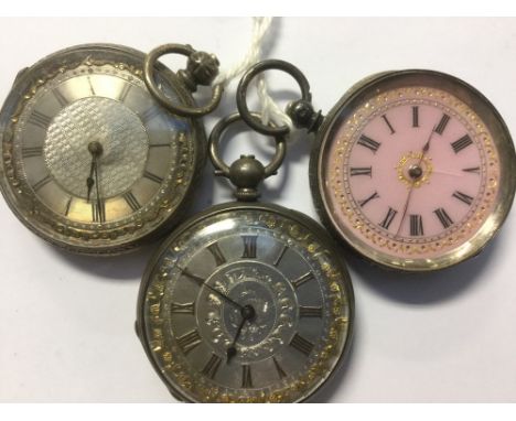 A group of three ladies silver pocket watches comprising one with a pink enamel dial and gilt decoration with heavily engrave